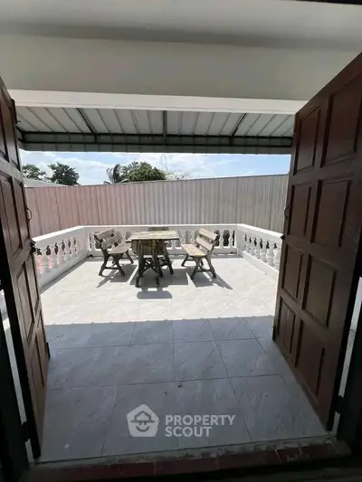 Spacious balcony with outdoor seating and tiled flooring, perfect for relaxation and entertaining.