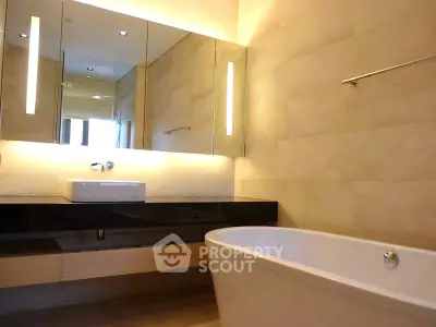 Luxurious modern bathroom with elegant bathtub and sleek vanity mirror.