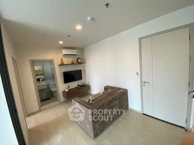 Modern living room with cozy sofa and wall-mounted TV in a stylish apartment.