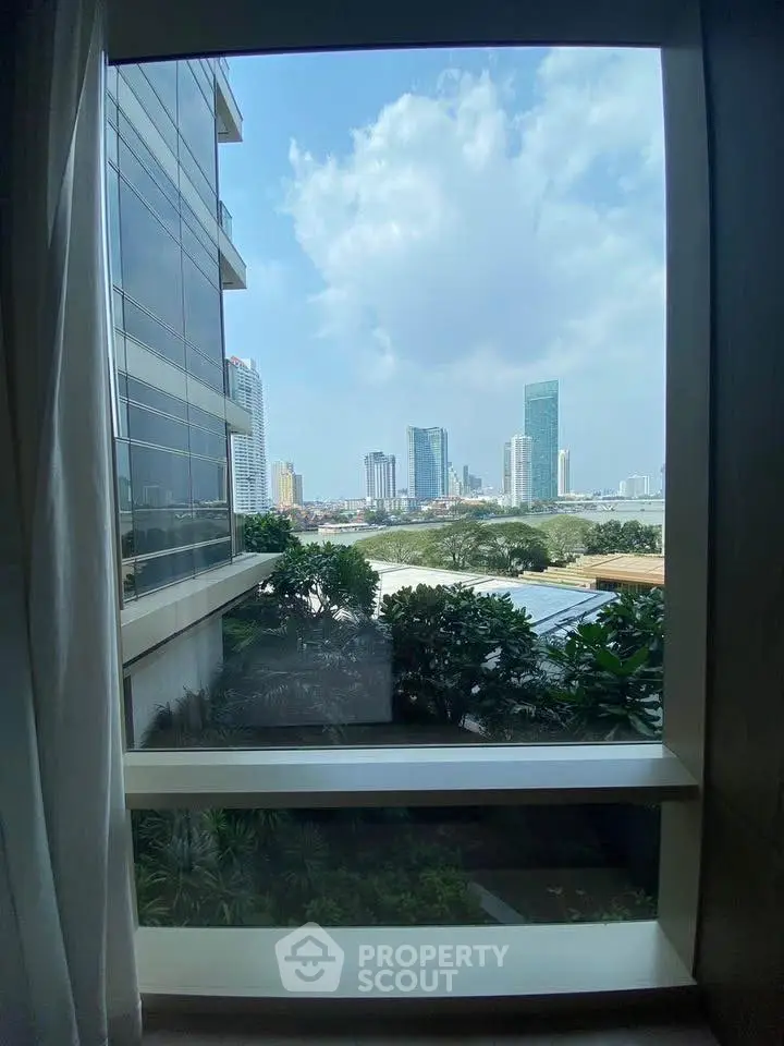 Stunning cityscape view from a modern apartment window, showcasing urban skyline and lush greenery.