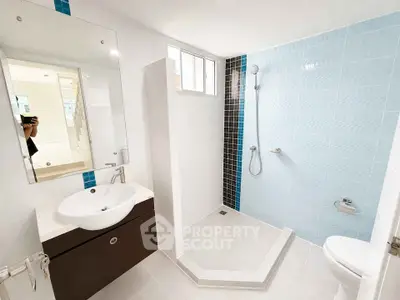 Modern bathroom with sleek design and walk-in shower in a bright apartment.