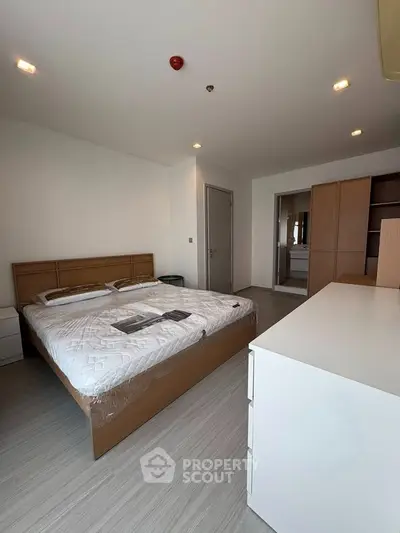 Spacious bedroom with modern furnishings and ample natural light in a stylish apartment.
