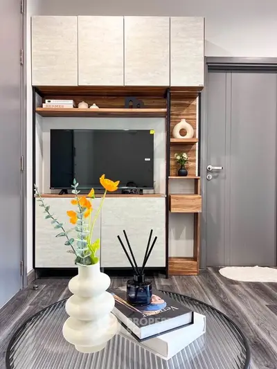 Modern living room with stylish TV unit and decorative elements, showcasing contemporary interior design.
