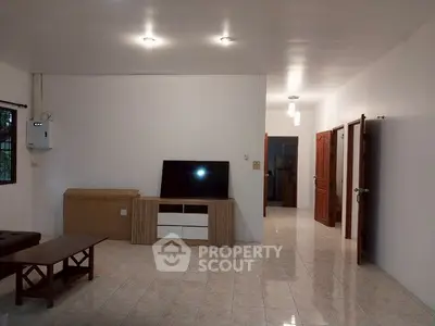 Spacious living room with modern furniture and tiled flooring in a well-lit home.