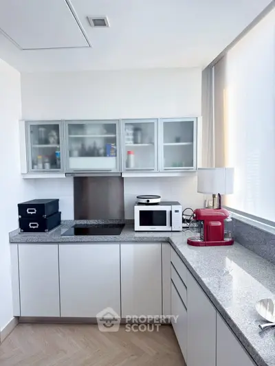 Modern kitchen with sleek cabinets, granite countertops, and built-in appliances in a bright, airy space.