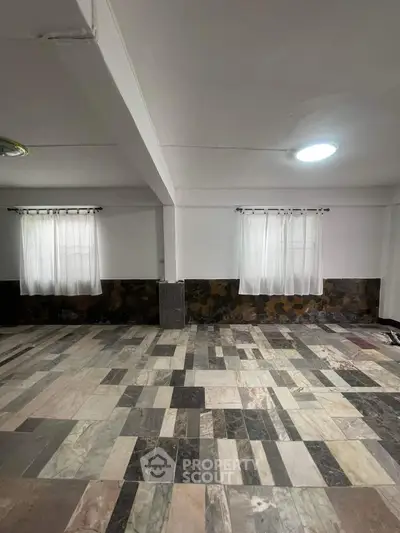 Spacious room with unique tile flooring and natural light