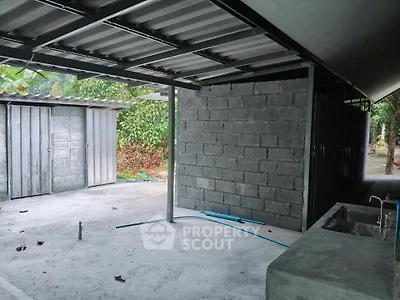 Spacious outdoor area with unfinished concrete structure and metal roofing, ideal for customization.