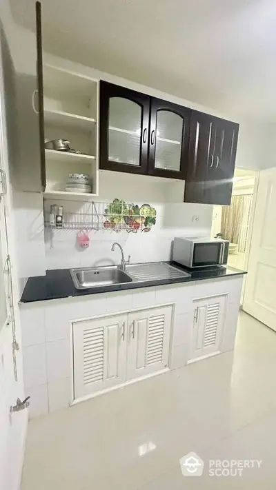 Modern kitchen with sleek cabinetry and stainless steel sink in a bright apartment