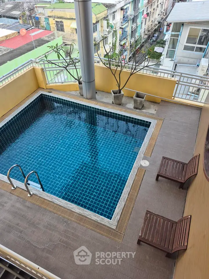 Charming rooftop pool with city views and relaxing lounge chairs, perfect for urban living.