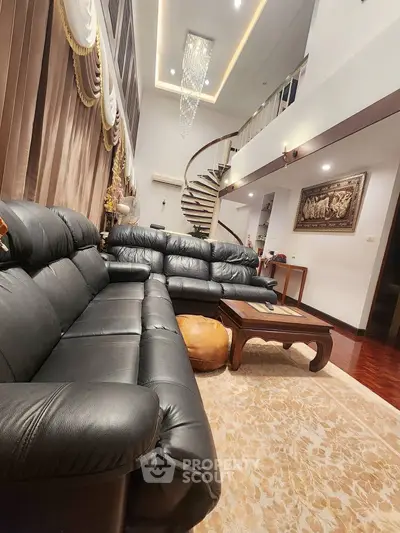 Luxurious living room with elegant spiral staircase and plush leather sofas