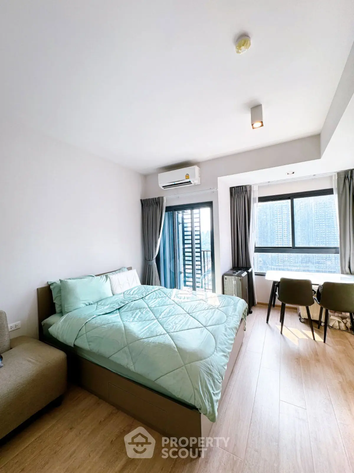 Modern bedroom with large windows and stylish decor in a high-rise apartment.