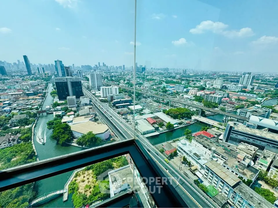 Stunning panoramic city view from high-rise building with expansive skyline and river.