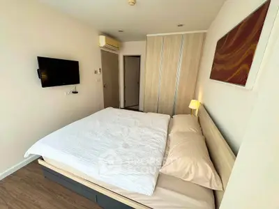 Modern bedroom with stylish decor and wall-mounted TV in a cozy apartment.