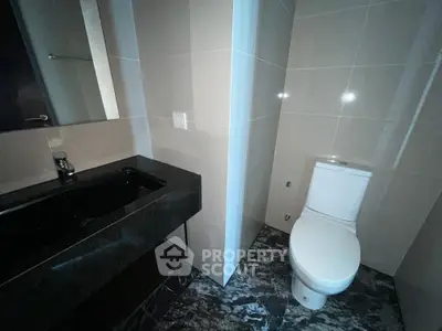 Modern bathroom with sleek black sink and tiled walls