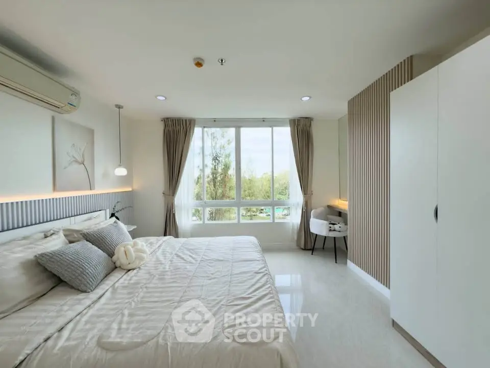 Spacious modern bedroom with large window and elegant decor