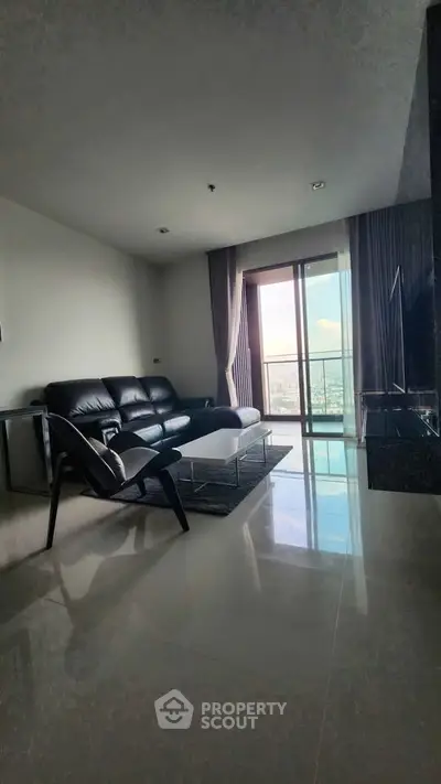 Spacious modern living room with leather sofa and city view balcony