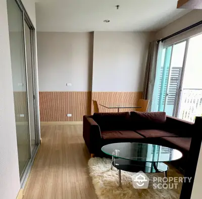 Modern living room with cozy brown sofa and glass coffee table, featuring a stylish wooden accent wall.