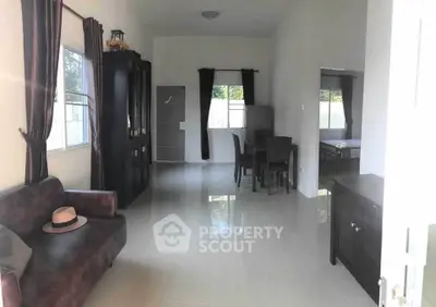 Spacious living room with elegant dark furniture and natural light