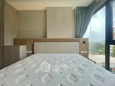 Modern bedroom with large window and scenic view, featuring a comfortable bed and stylish decor.