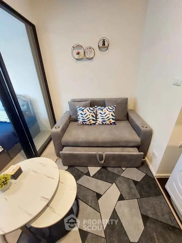 Cozy living room with modern gray sofa and geometric rug