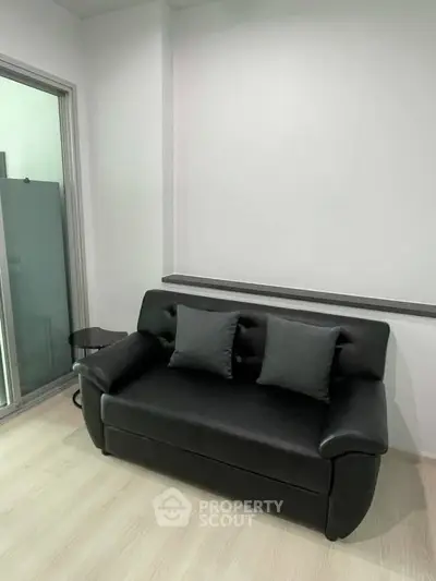 Modern living room with sleek black sofa and minimalist decor