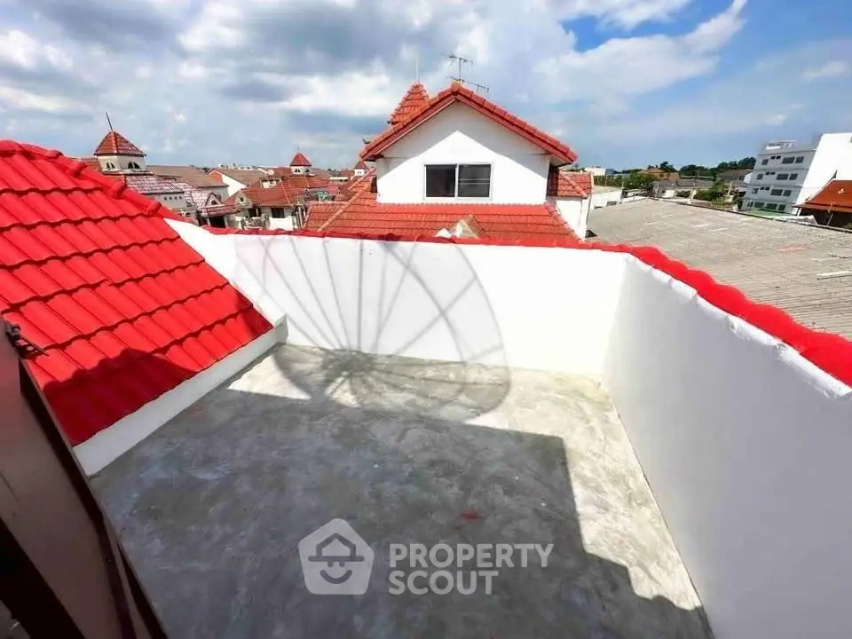 Charming rooftop terrace with red-tiled roofs and expansive sky views, perfect for relaxation and outdoor enjoyment.