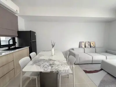 Modern open-plan living room with sleek kitchen and stylish marble dining table.