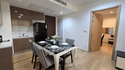 Modern open-layout kitchen and dining area with sleek furniture and wooden flooring.