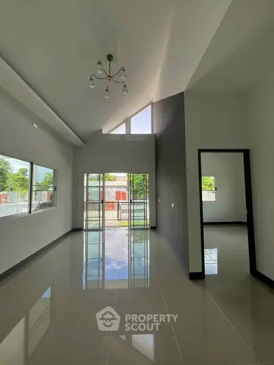 Spacious modern living room with high ceilings and large windows offering natural light.