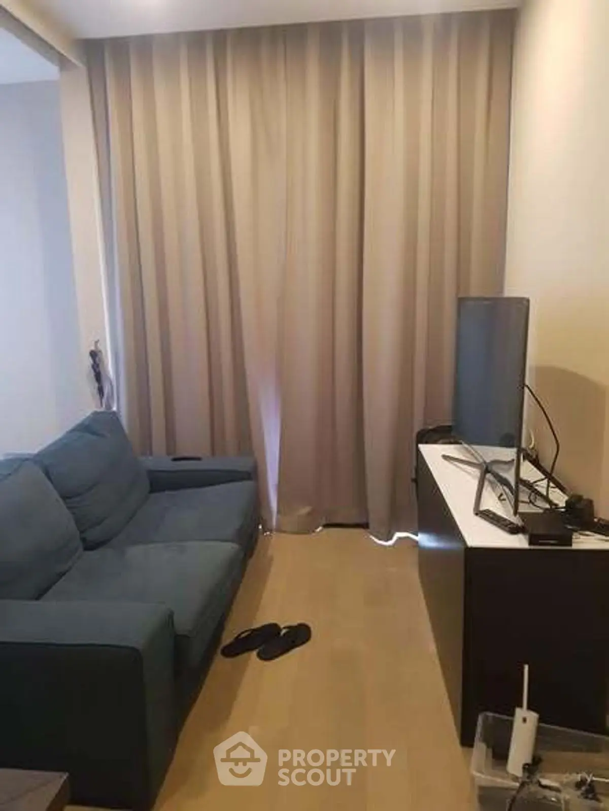 Cozy living room with modern sofa and TV setup, perfect for relaxation.