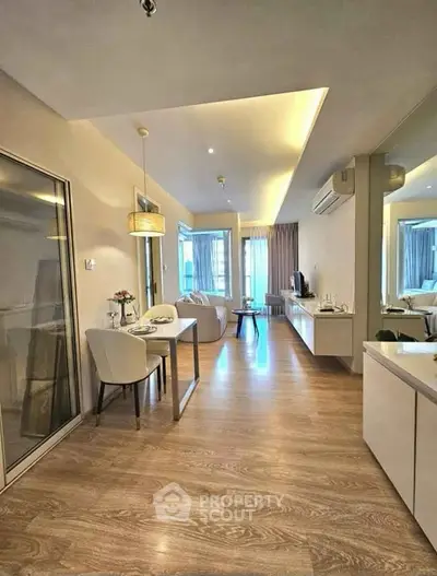 Modern open-plan living room with elegant dining area and large windows.