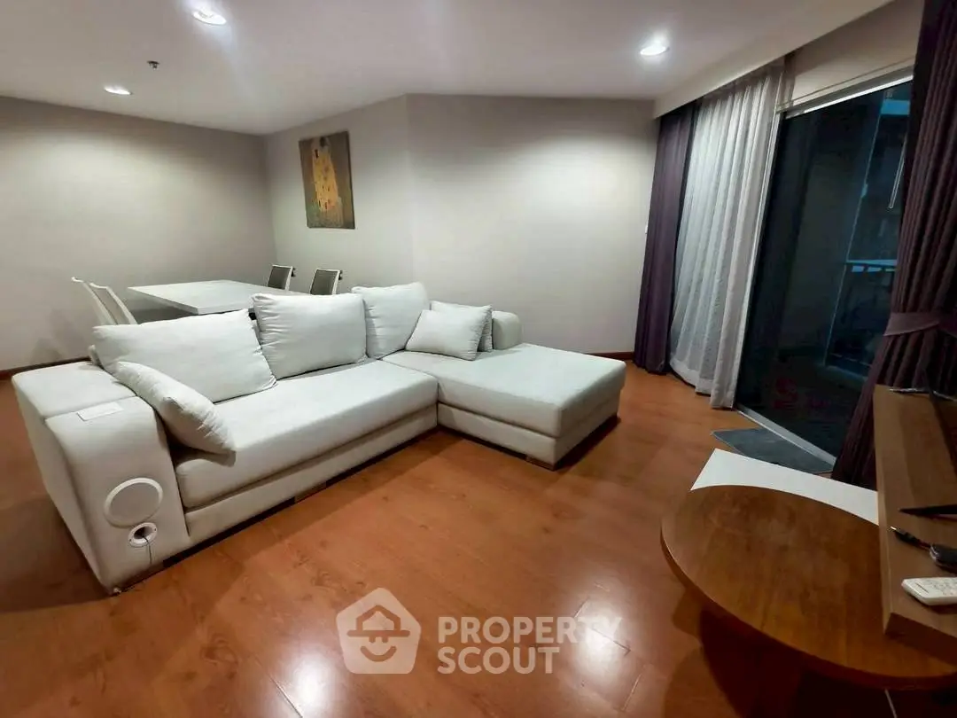Spacious living room with modern L-shaped sofa and elegant dining area.