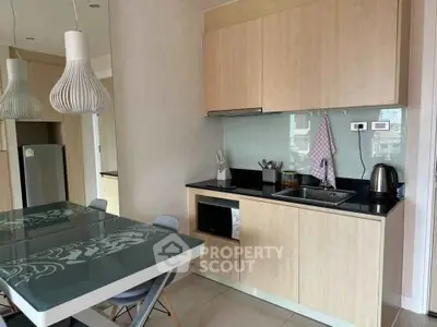 Modern kitchen with sleek cabinetry and dining area in stylish apartment