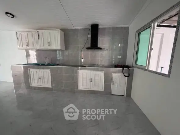 Modern kitchen with sleek cabinetry and tiled backsplash in a contemporary home.