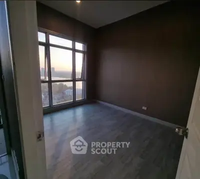 Spacious empty room with large windows offering stunning city views.