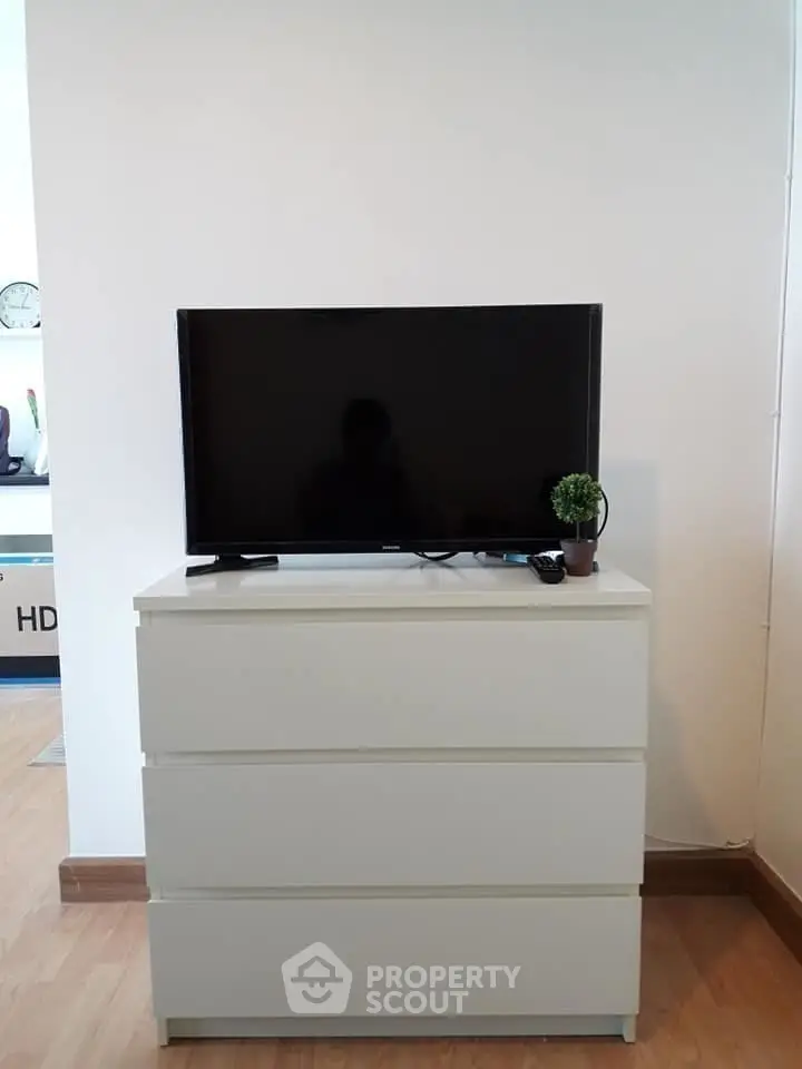 Modern living room with sleek TV setup on white dresser, perfect for cozy entertainment.
