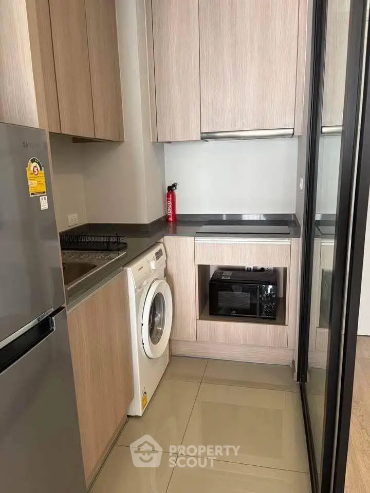 Modern compact kitchen with washing machine and sleek appliances