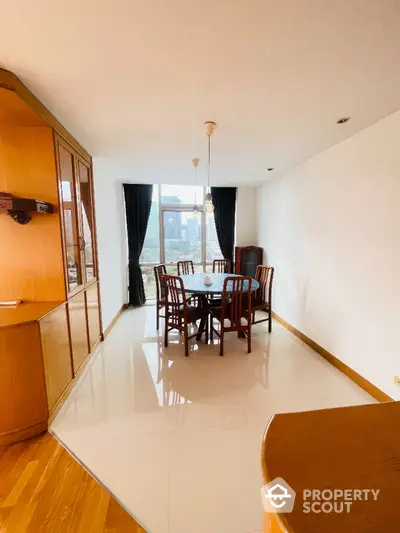 Spacious dining area with elegant wooden furniture and large window view