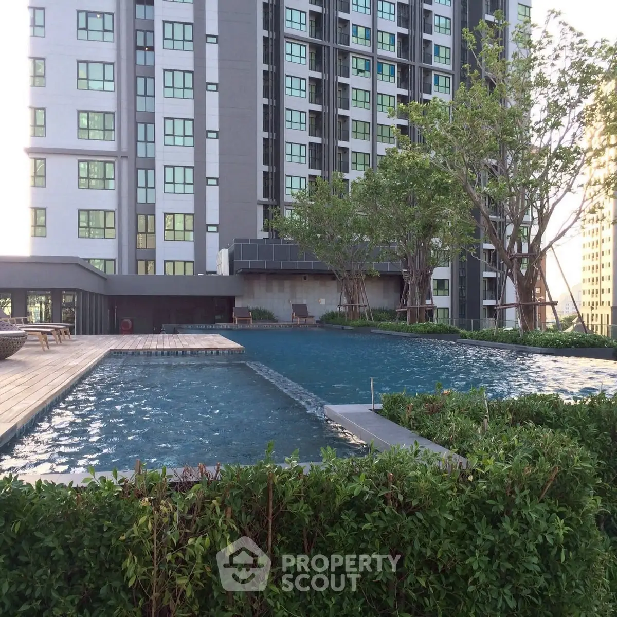 Luxurious high-rise building with serene outdoor pool and lush greenery