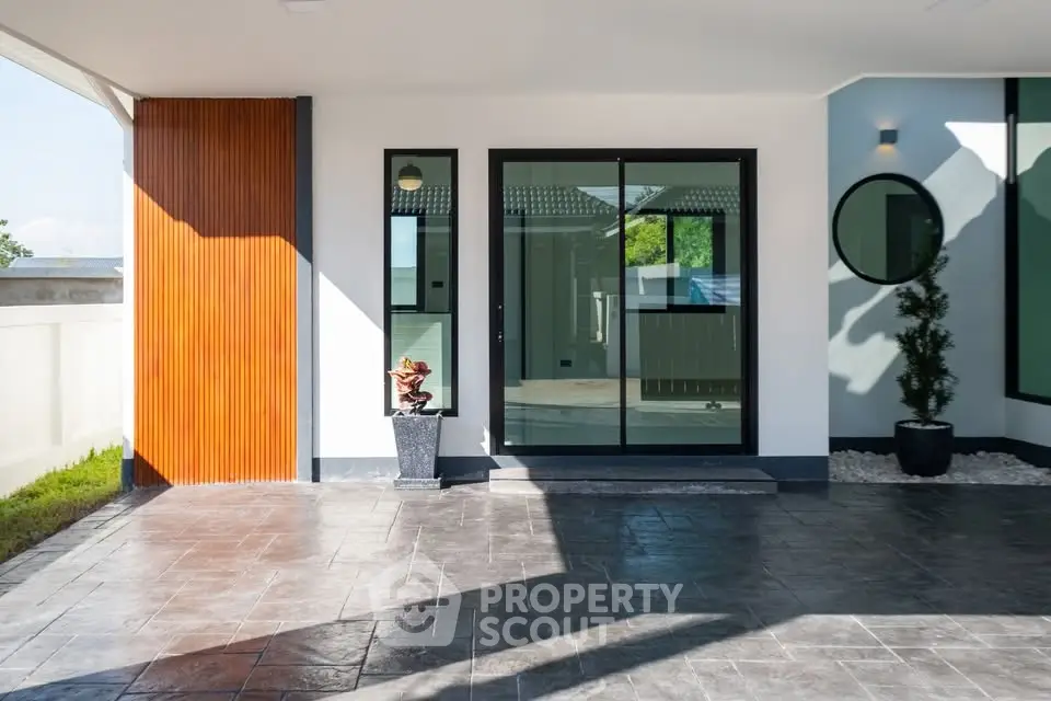 Modern house entrance with sleek glass doors and stylish exterior design.
