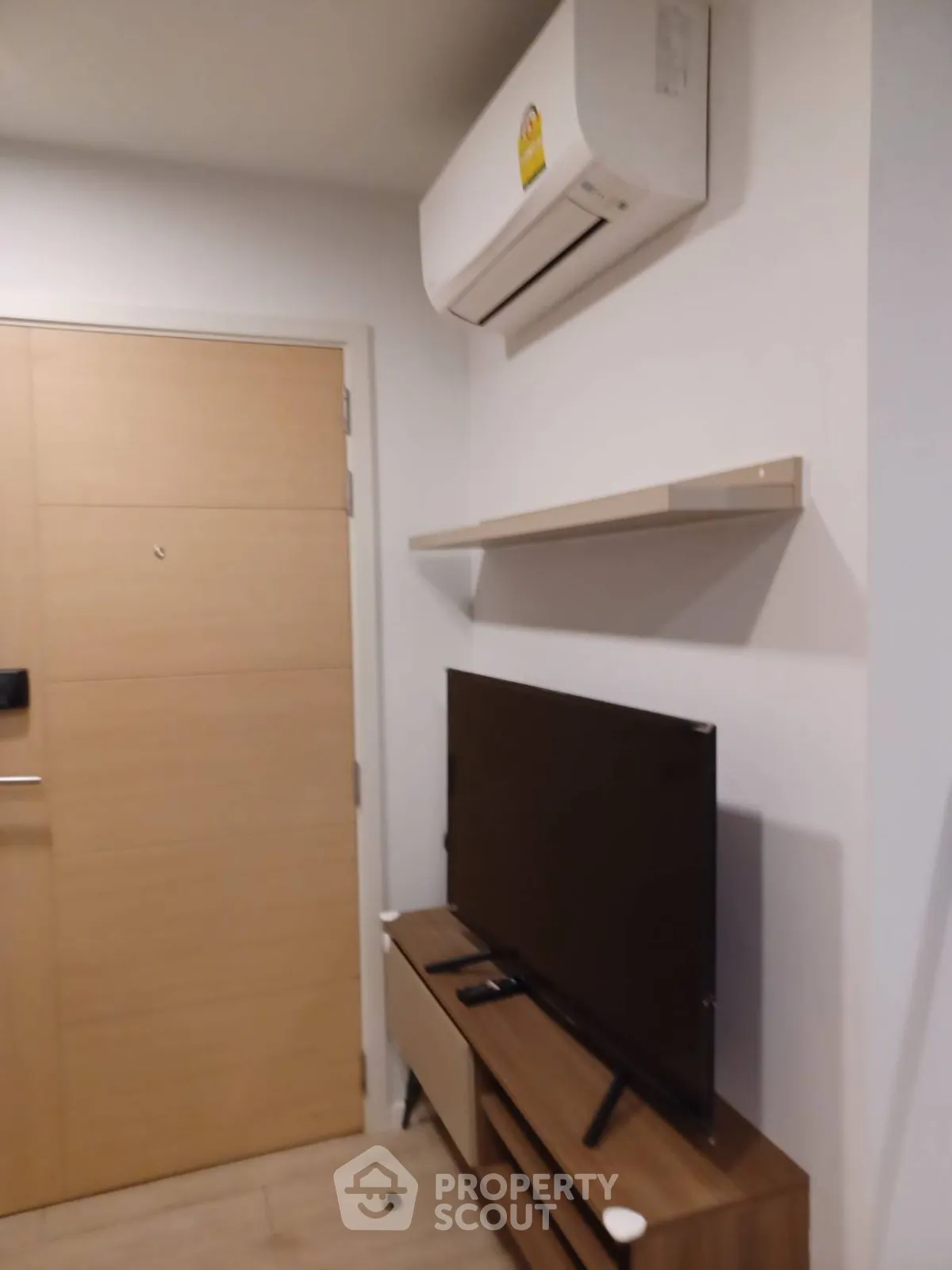 Modern living room with air conditioning and flat-screen TV setup.