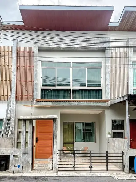 Modern townhouse exterior with stylish facade and small front patio.