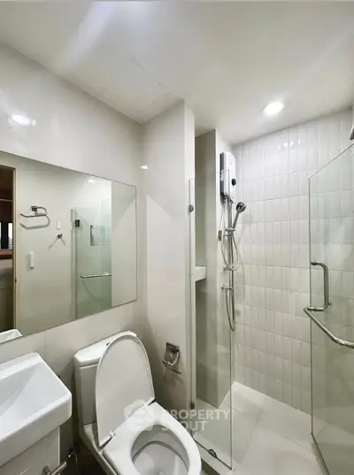 Modern bathroom with glass shower and sleek fixtures in a contemporary home.