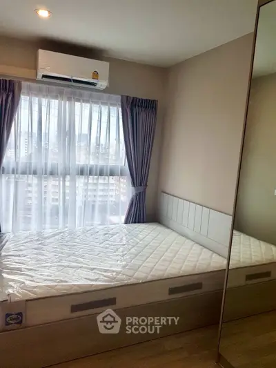 Modern bedroom with large window and city view, featuring a comfortable bed and air conditioning.