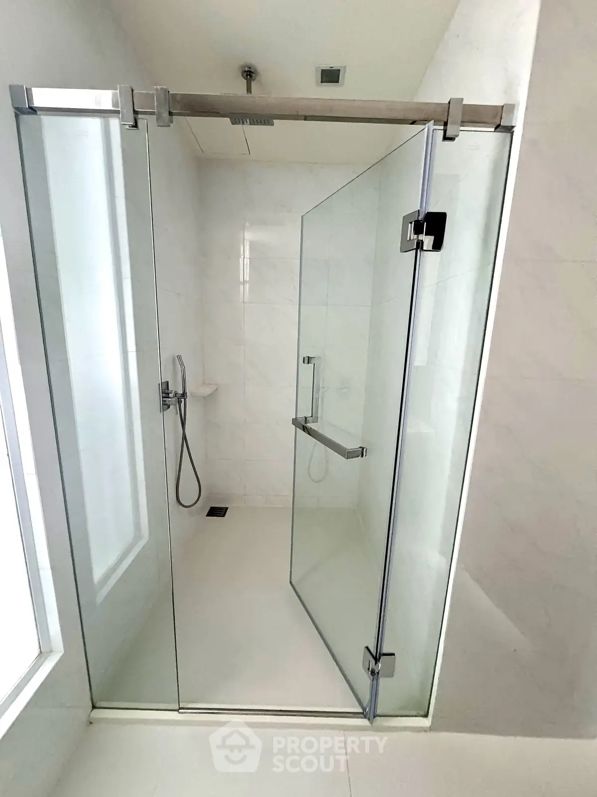 Modern bathroom with sleek glass shower enclosure and minimalist design.