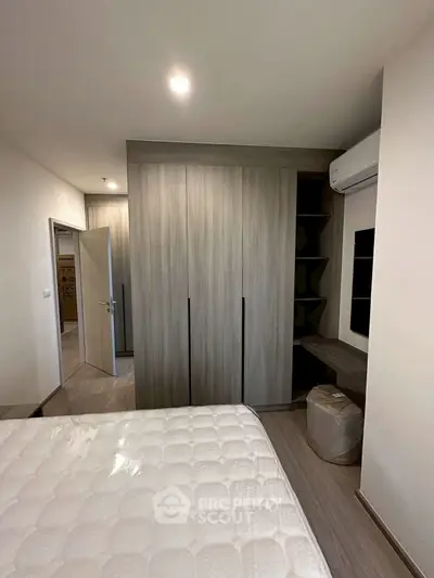 Modern bedroom with built-in wardrobe and air conditioning unit