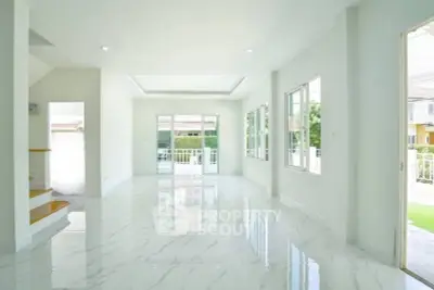 Spacious modern living room with glossy marble floors and large windows for natural light.