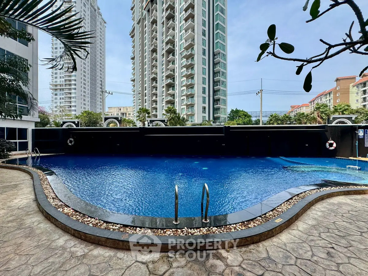 Luxurious residential pool with modern high-rise buildings in the background, perfect for relaxation and leisure.