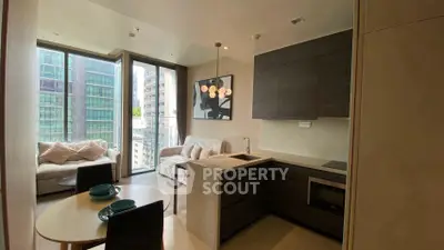 Modern open-layout kitchen and living room with large windows and stylish decor.