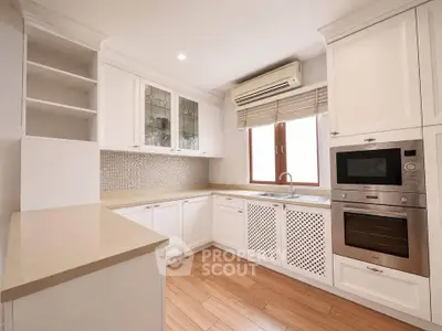 Modern kitchen with sleek cabinetry, built-in oven, and elegant countertops in a bright, airy space.